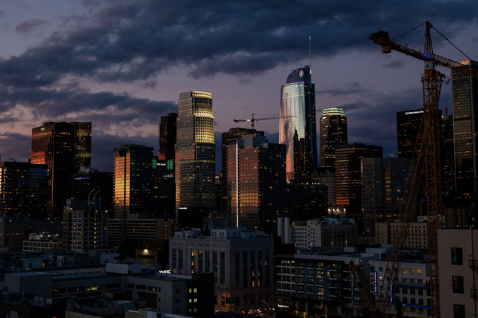 Downtown Los Angeles skyline at dusk under dark clouds
