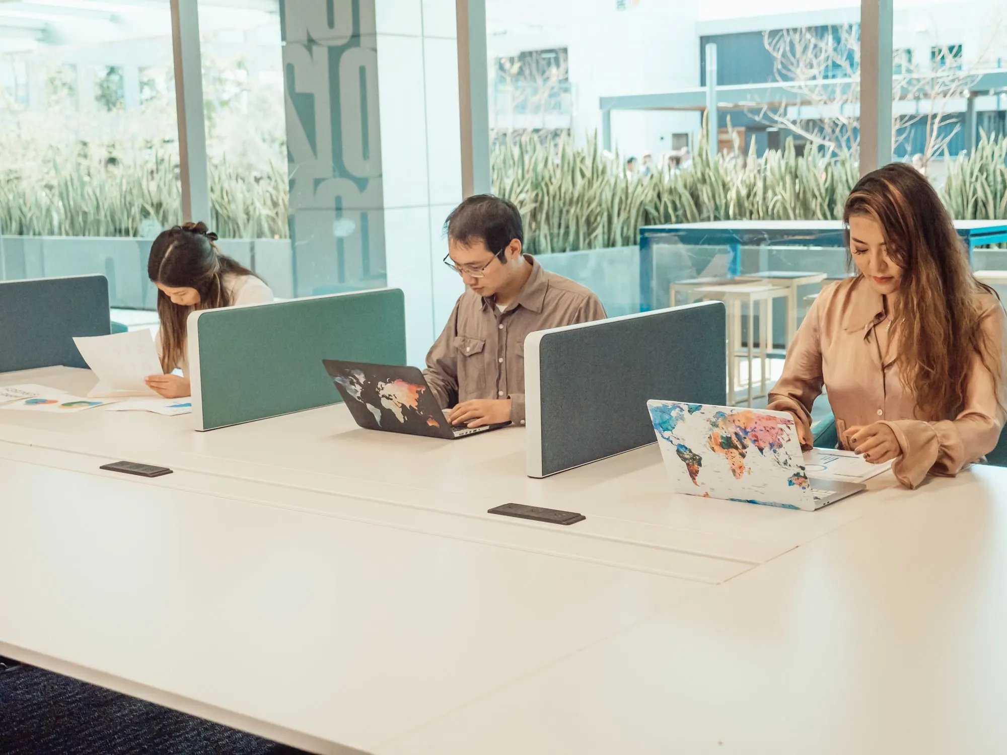 People working at laptops in a bright modern open-plan office